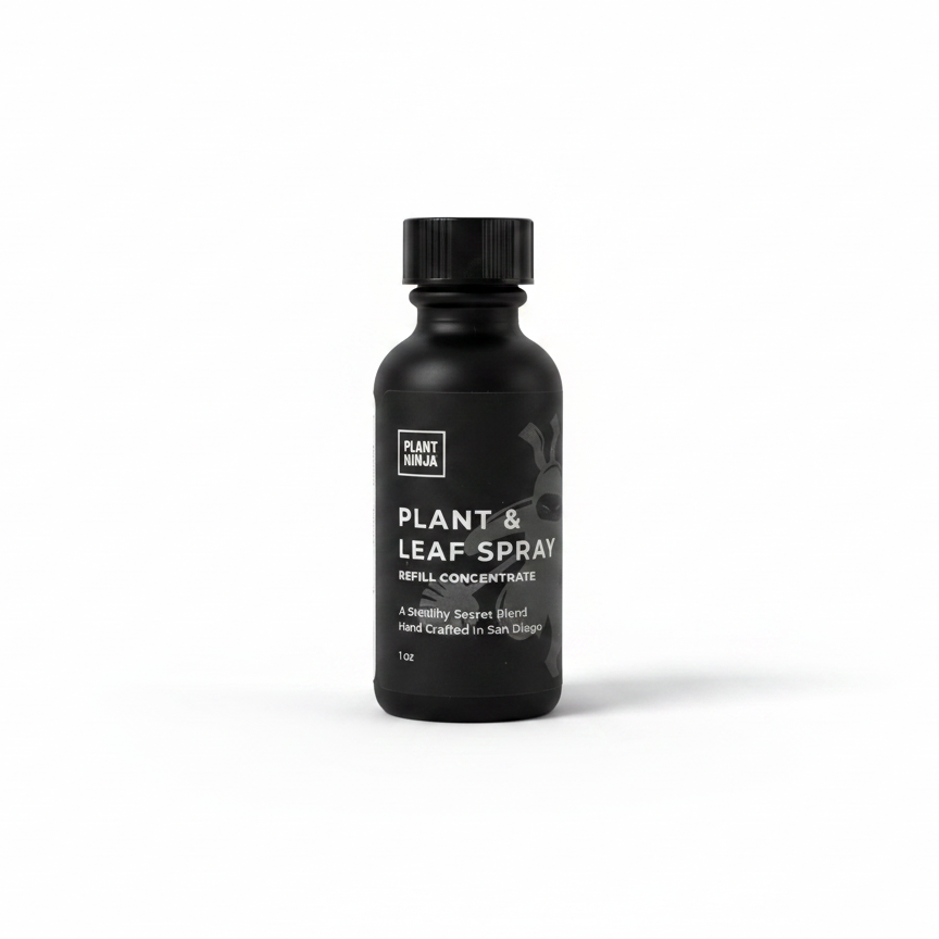 Black bottle of plant and leaf spray on a white background